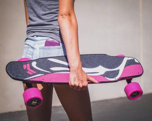 Girl Carrying Miles Electric Skateboard