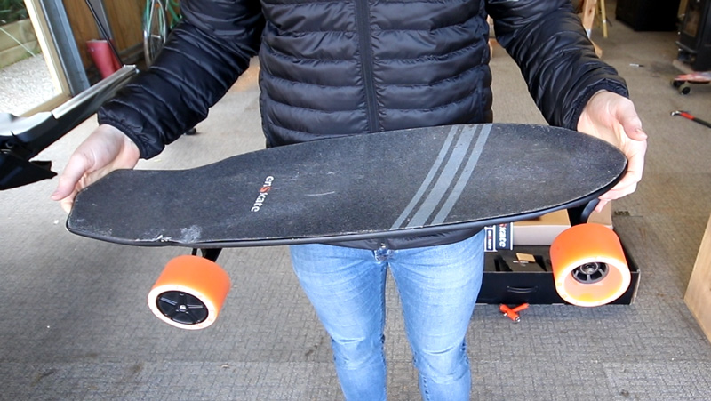 Holding the enSkate R3 Mini electric skateboard