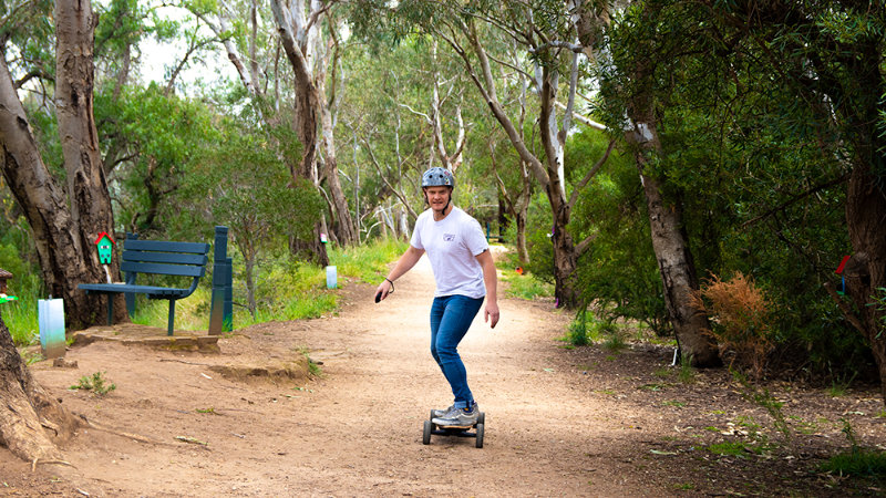 riding electric skateboard on dirt trail