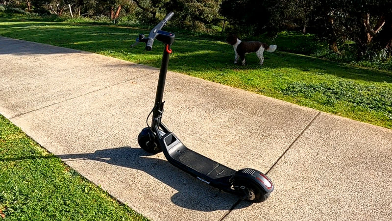 The maxfind Glider G5 electric scotoer on a sunny day with dog in the background